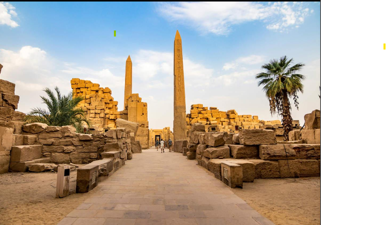 The massive entrance pylons of Edfu Temple decorated with ancient Egyptian carvings and hieroglyphics, with visitors exploring the historic site.