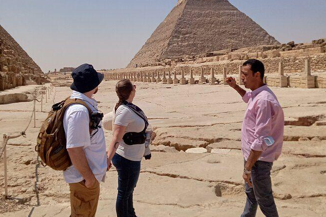 Is Egypt safe for tourism? Tourists visiting the Pyramids of Giza with a local guide in Cairo