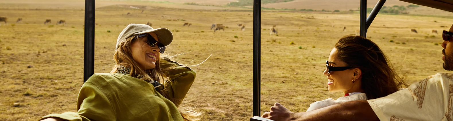 insured travelers enjoying the breeze on an open safari vehcle